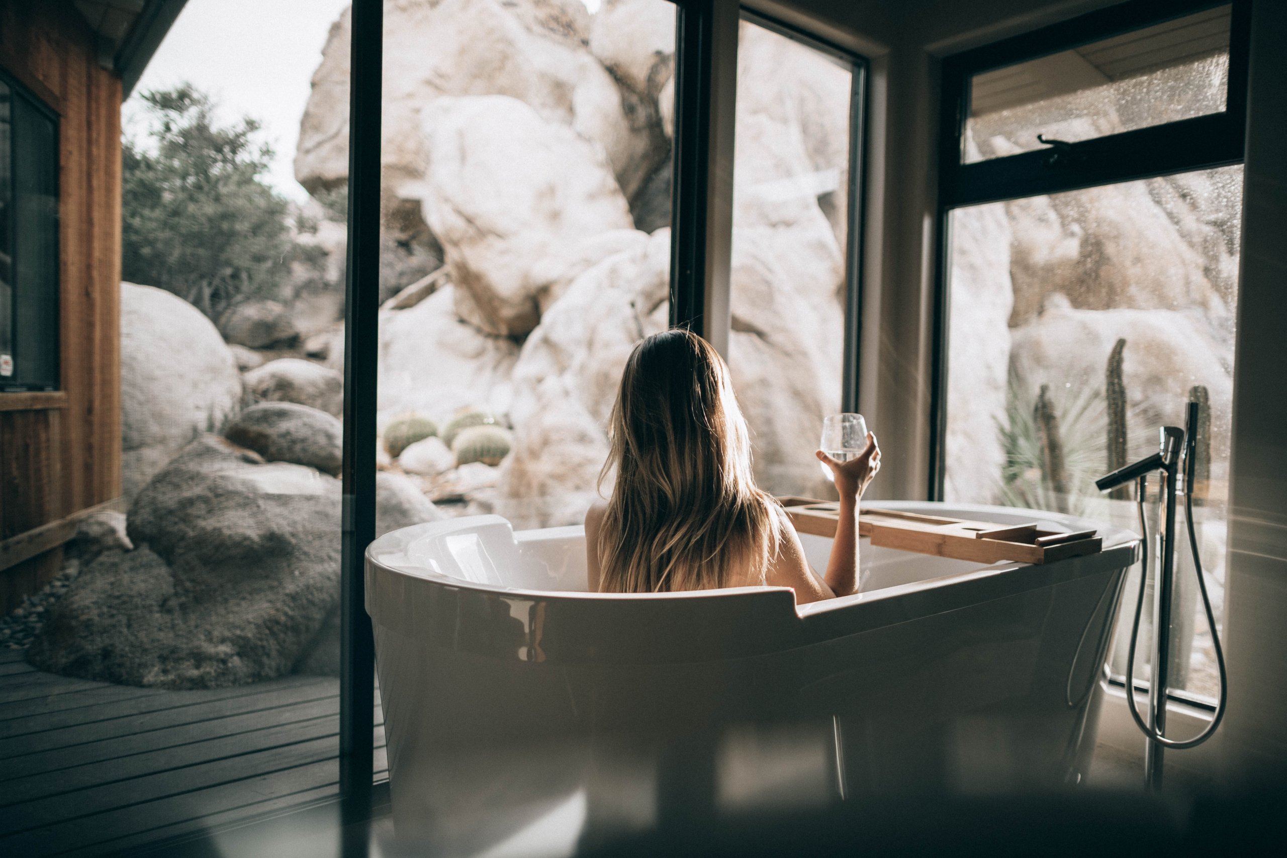 a lady in the tub relaxed and with a glass of water